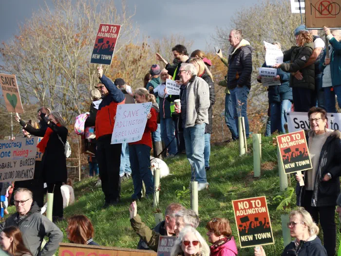 Crowds standing on hillside holding placards