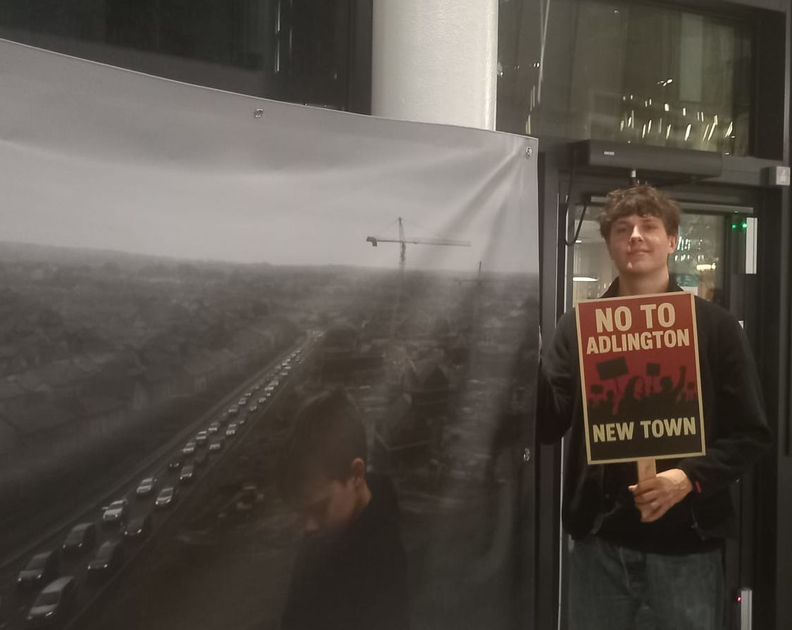Man holding a banner and No to Adlington New Town placard