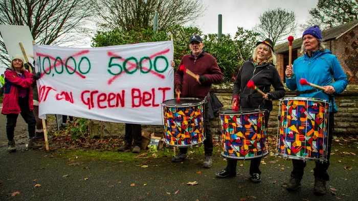 Drummers next to a large banner opposing Adlington New Town