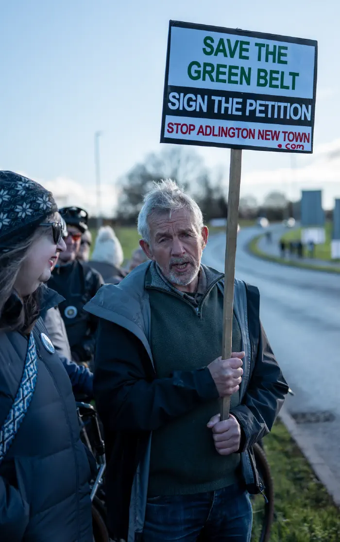 Man holding Save The Greenbelt placard