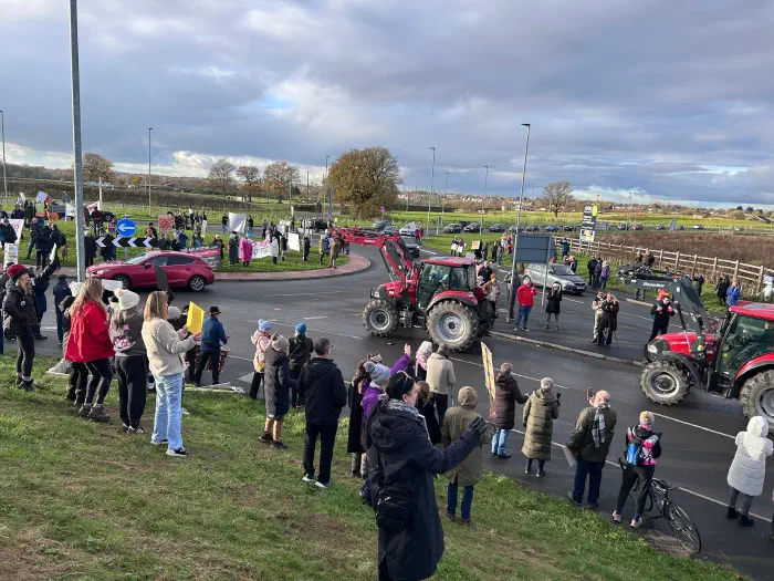 Tractors approaching the roundabout taken from hillside covered in protesters