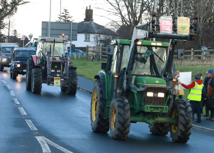 Tractors on the road displaying Save Adlington banners