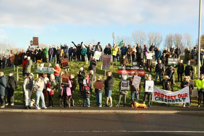 The hill next to the roundabout packed full of protesters with banners and placards united in their opposition to Adlington New Town