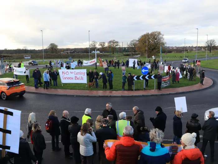 Taken from the hillside of the roundabout full of protesters holding banners and placards