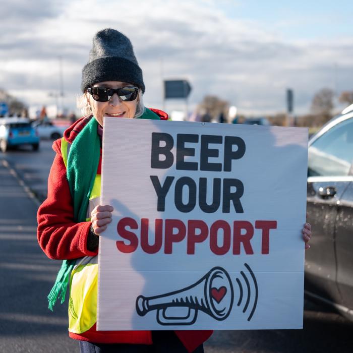 Green John Deere Tractor on the roundabout with Save Adlington placard on front surrounded by protesters