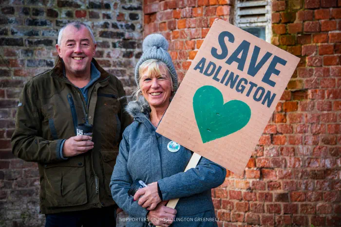 2 Protesters at Tatton Park with Save Adlington green heart placard