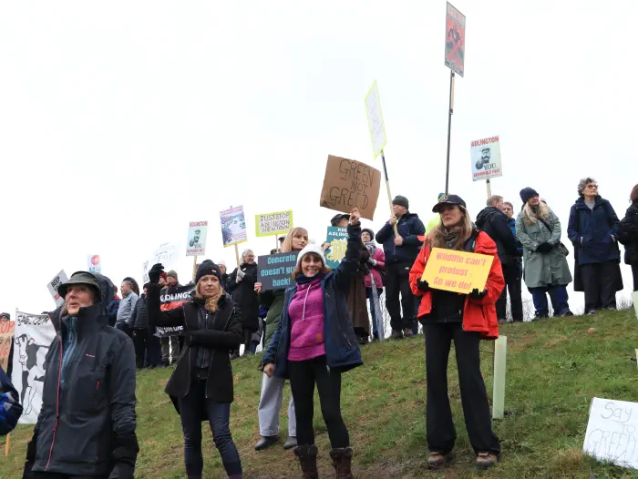 Protesters on embankment near roundabout with placards