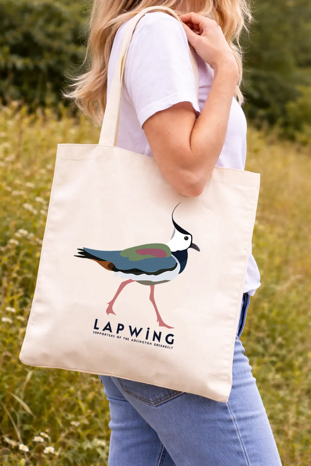 Woman holding bag featuring a lapwing. Caption Supporters of the Adlington Greenbelt.